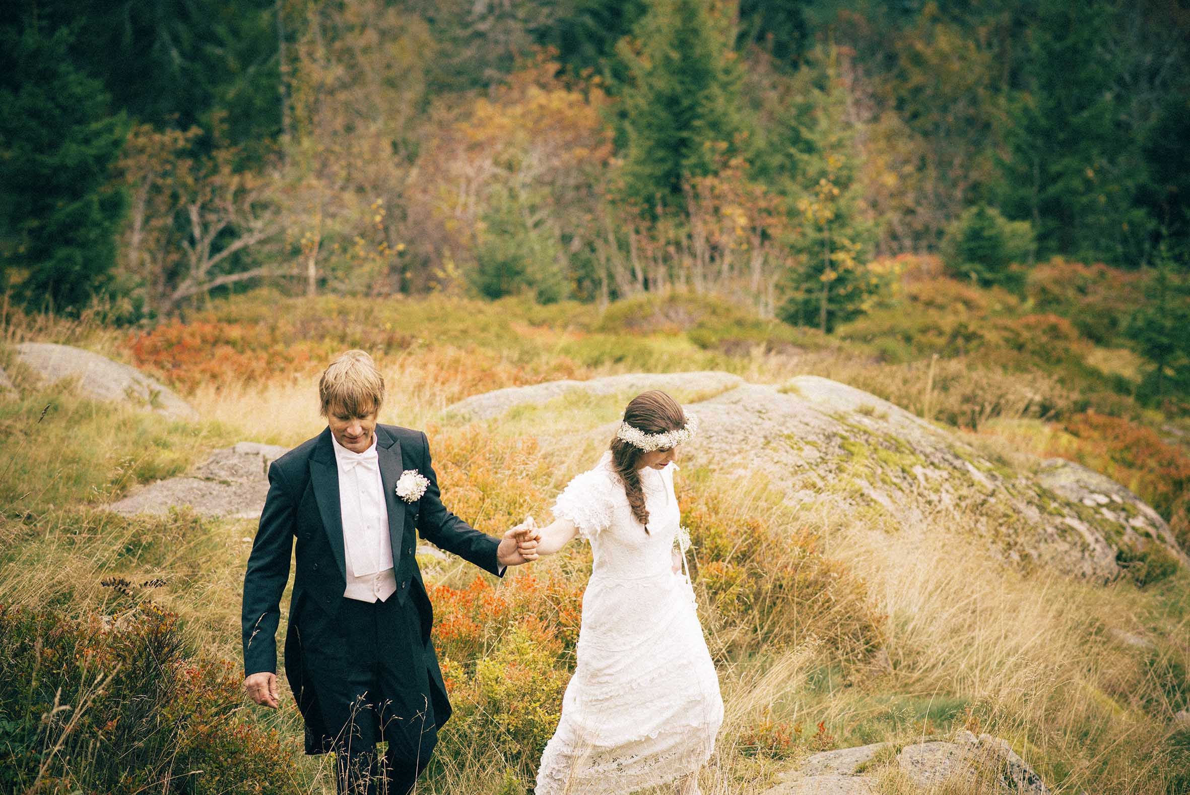 høstbryllup, mann og kvinne går sammen i skogen