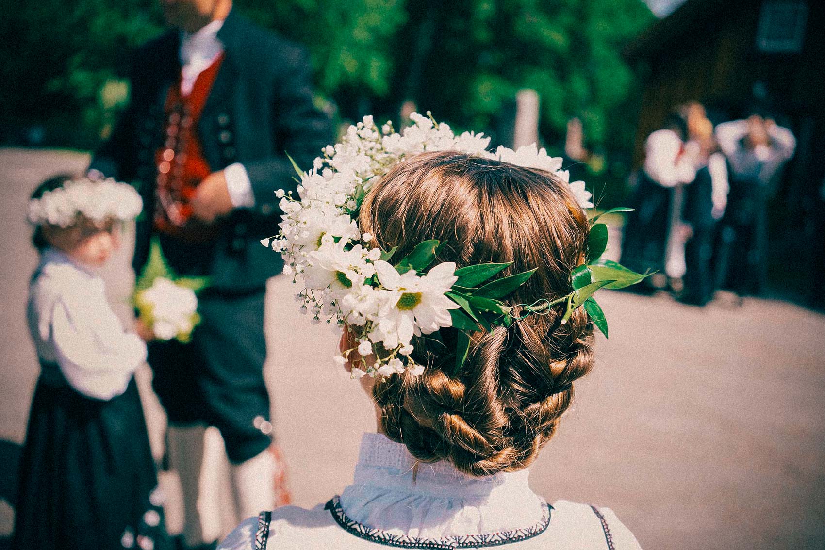 pike med bunad er gjest i bryllup, hun har blomster i håret