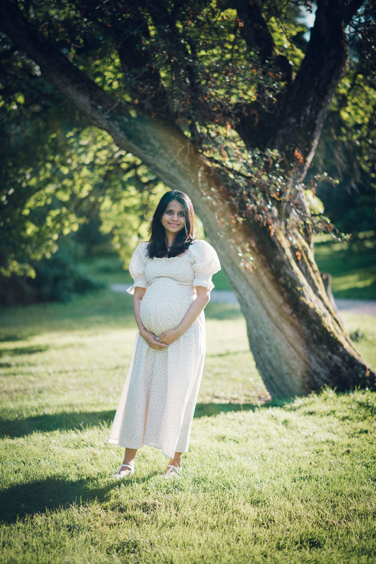 bilde av en gravid kvinne som smiler og holder rundt magen