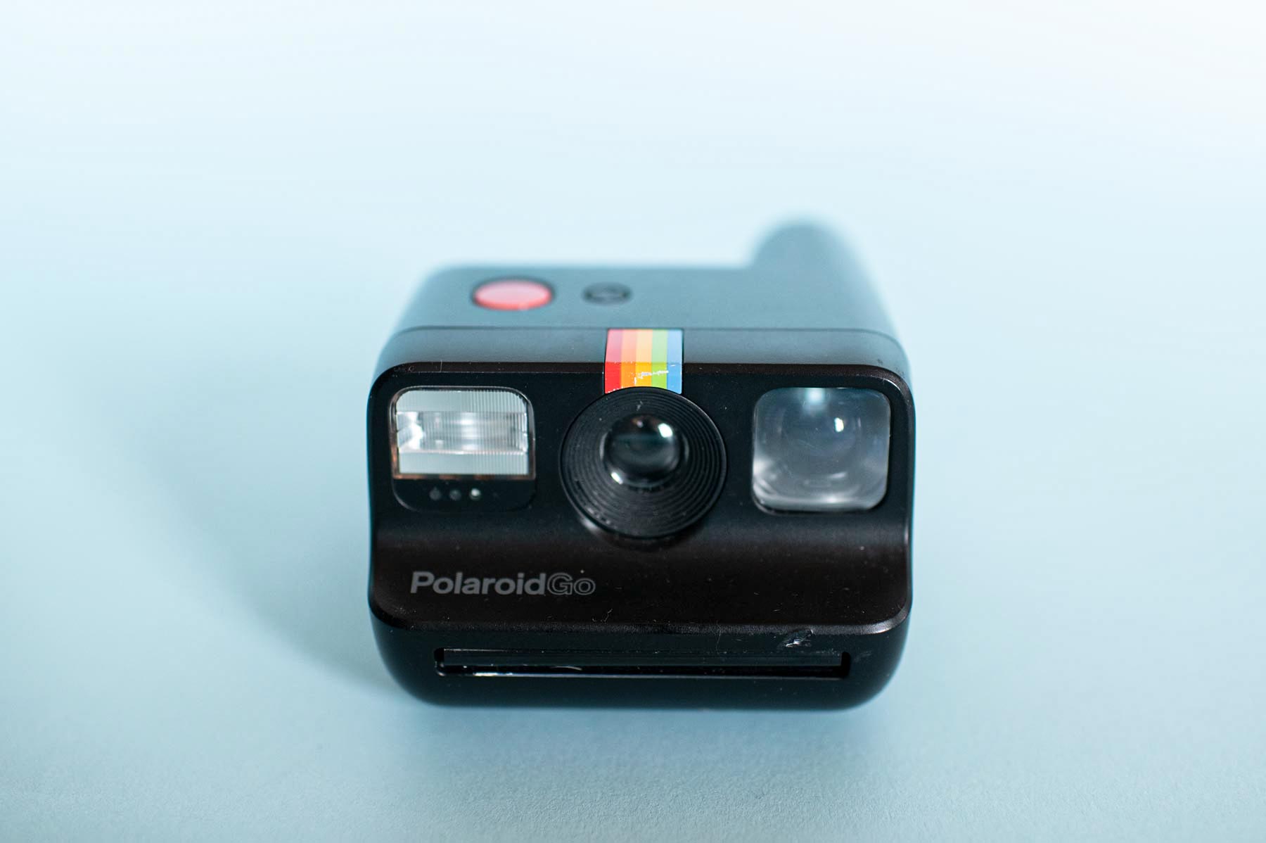 Bilde av et lite Polaroidkamera med blå bakgrunn